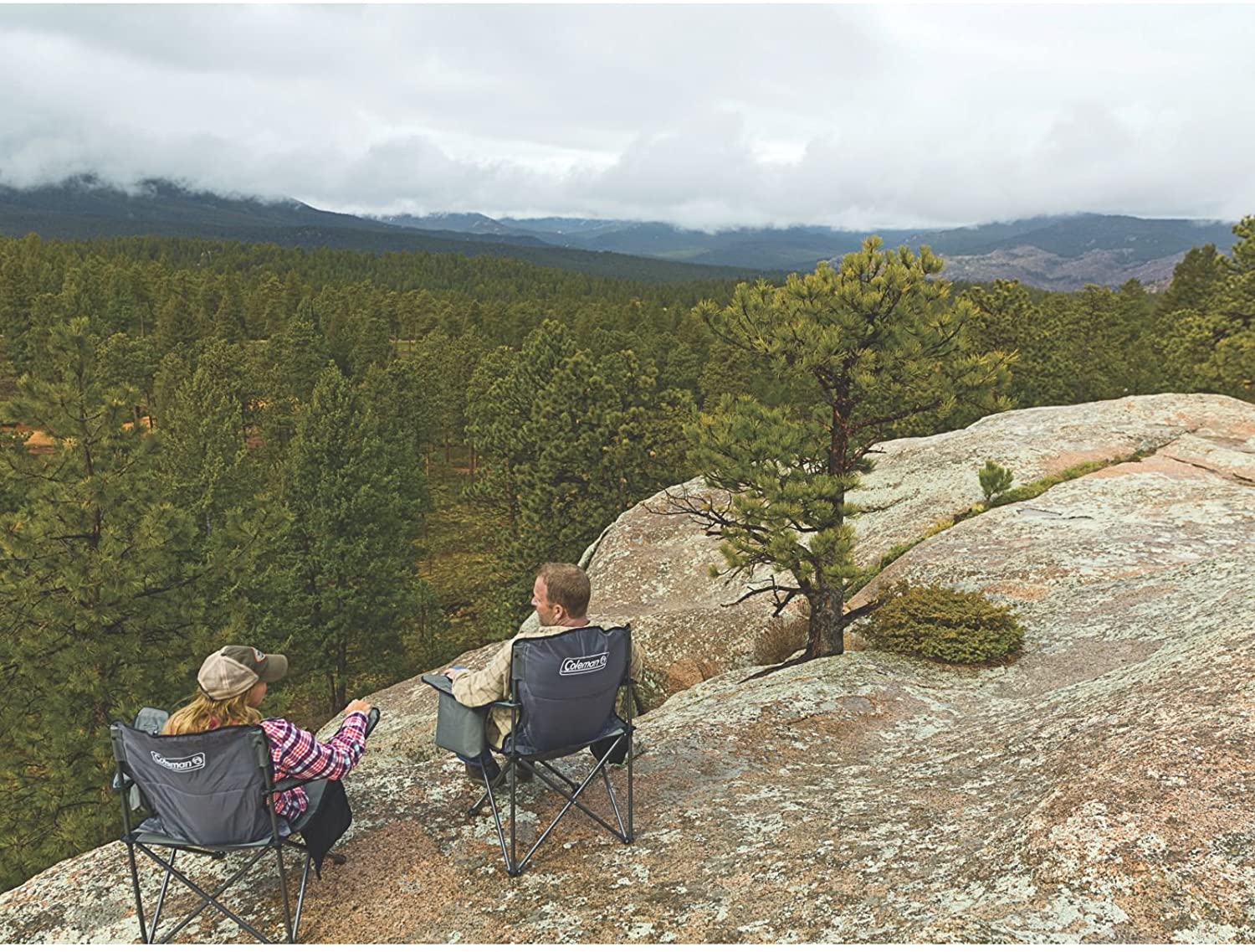 two people on rock ledge sitting in Coleman Chair