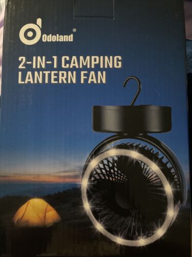 camping fan and light with lit up tent in background at night